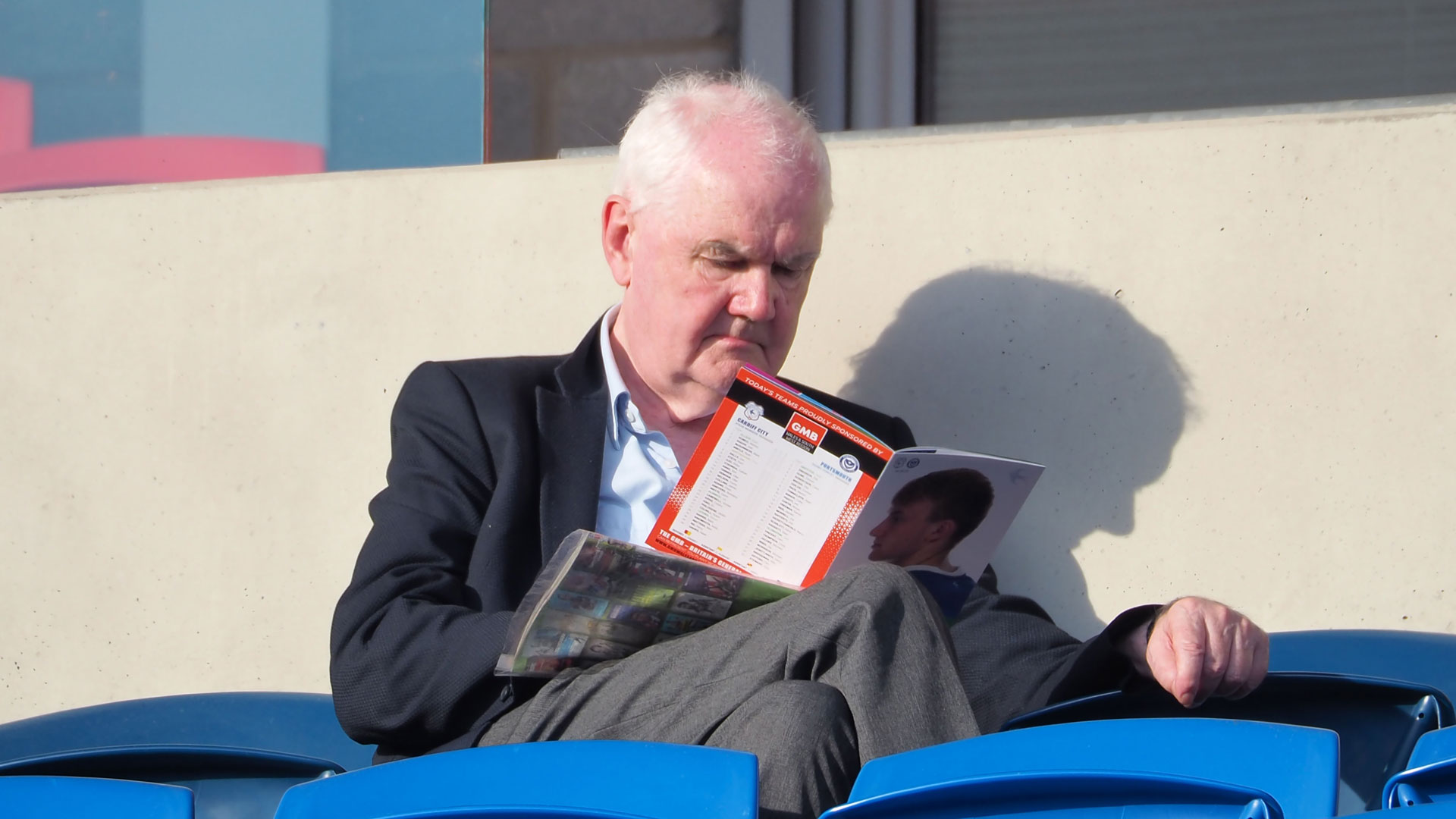 A fan reads The Bluebird - Official Matchday Programme...