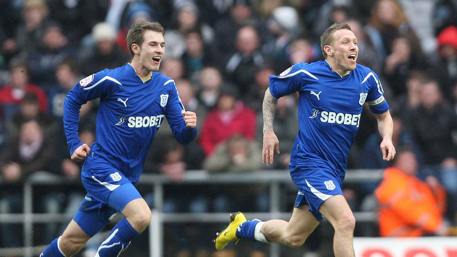 Craig Bellamy and Aaron Ramsey celebrate the winner against Swansea City...