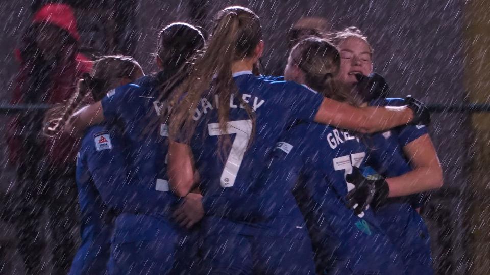 The Bluebirds celebrate a goal during the rain soaked game at Cyncoed...