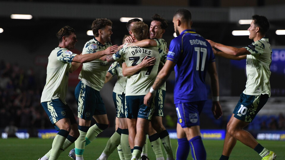 Isaak Davies celebrates with his teammates at AFC Wimbledon...