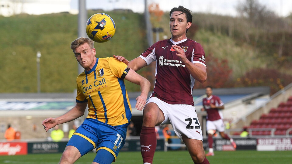 Will Evans battling for the ball against Mansfield Town.